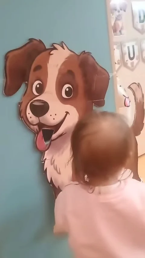 Dziewczynka bawi się przy dużym rysunku psa